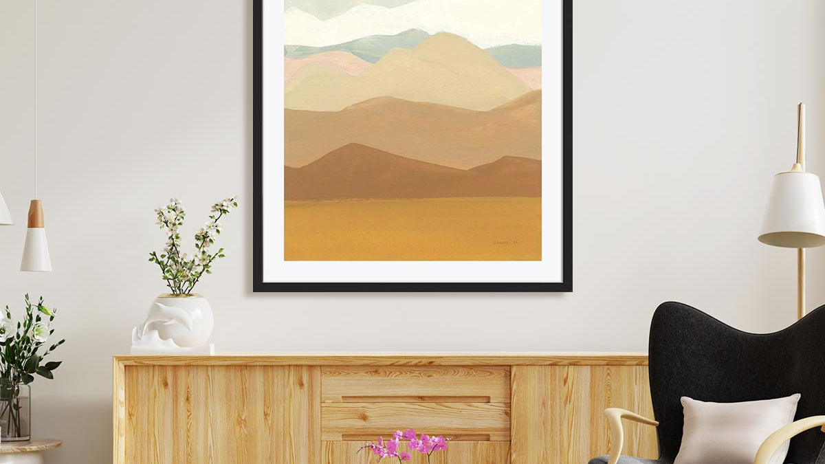 large wall art in black frame above a console table. There is a lounge chair in front.