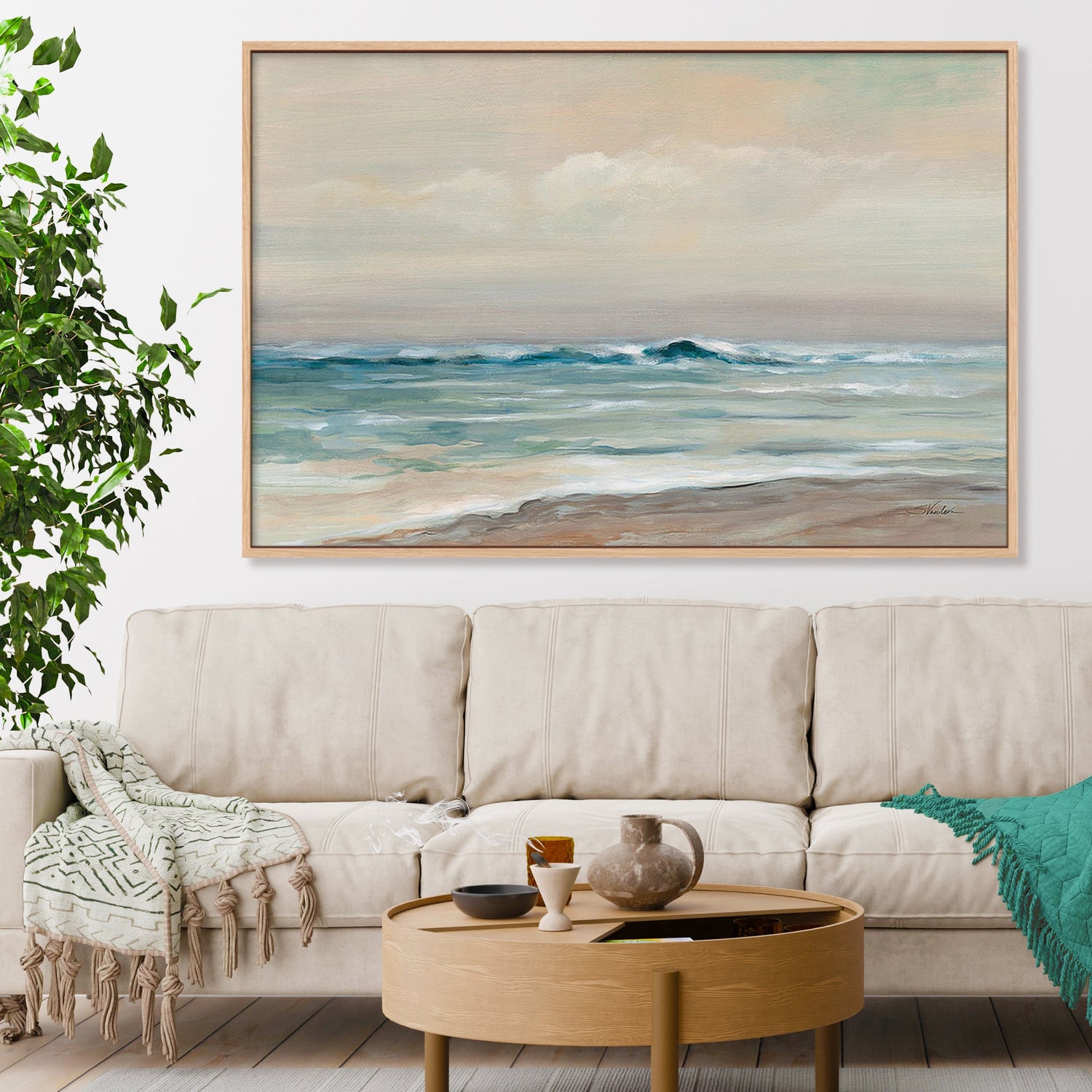 Extra large shadow gallery box in oak of a pastel coastal beach print hanging above a beige sectional sofa.